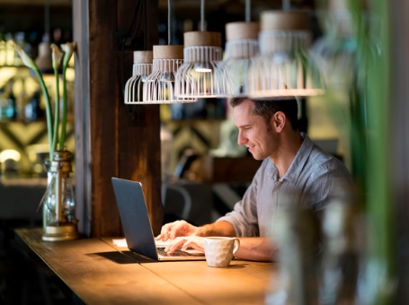 A man with smiley face is using his laptop after getting provided Managed IT Services, IT Solutions and IT Support in Madison