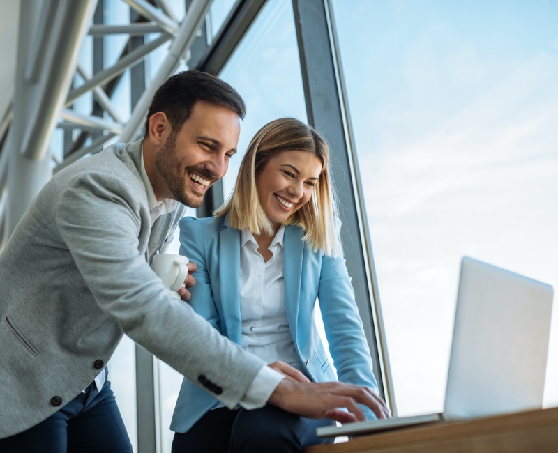 A man and a woman looking happy using Managed IT Services, IT Solutions and IT Support in Madison